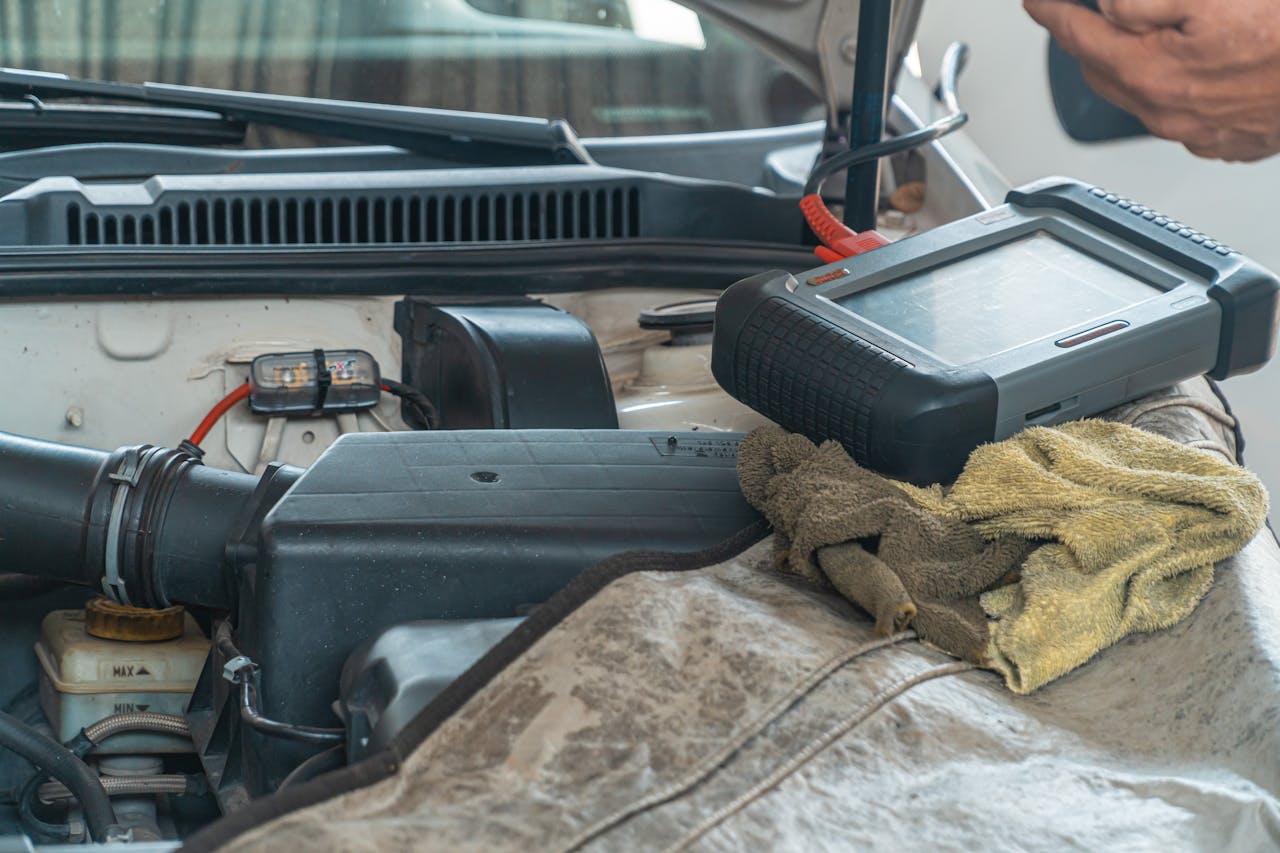 Home Close-up of a car engine inspection using a diagnostic tool in a garage setting, showcasing automotive maintenance and repair.