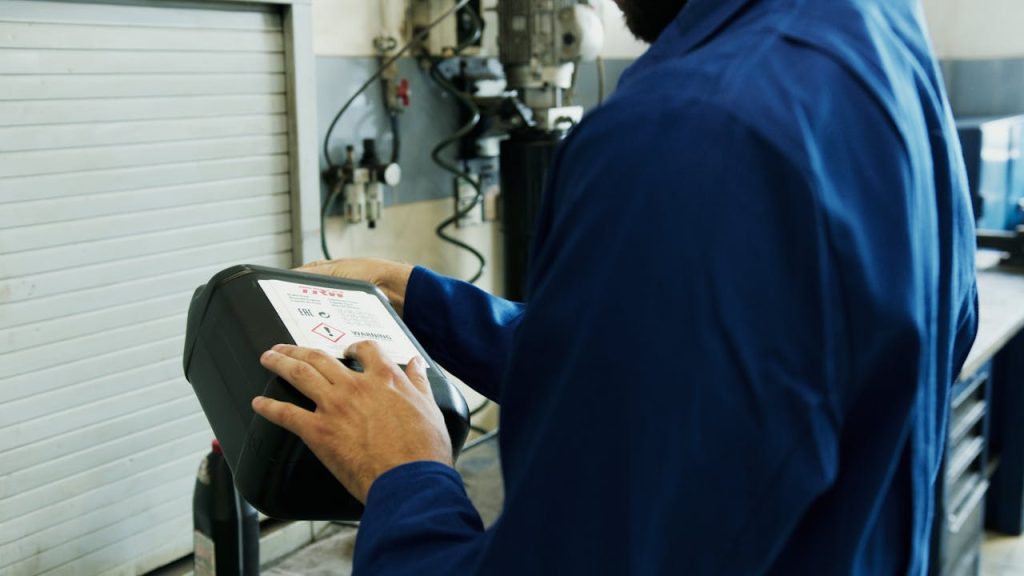 OBD2 Geek Mechanic using diagnostic tool to inspect vehicle in an automotive workshop.